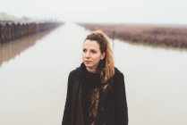 Ritratto di giovane donna sul lungomare del canale nebbioso — Foto stock