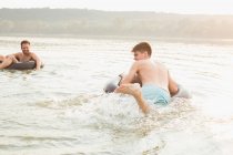 Freunde amüsieren sich mit aufblasbarem Ring im Fluss — Stockfoto