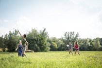 Група молодих людей, які грають бадмінтон в поле — стокове фото