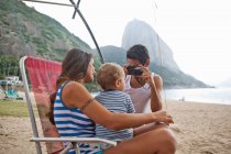 Man taking photograph of mother and son on chair, Rio de Janeiro, Brazil — Stock Photo