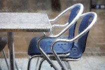 Журнальний столик і стільці через віконне скло в краплі дощу — стокове фото