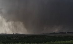 Vista de violento tornado de cunha envolto em chuva rasga terras agrícolas no Kansas rural — Fotografia de Stock