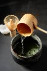 Matcha-Tee mit traditionellen Bambuswerkzeugen einschenken — Stockfoto