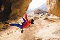 Mujer escalando en roca, Buttermilk Boulders, Bishop, California, Estados Unidos - foto de stock