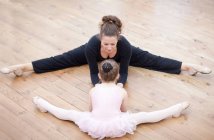Учитель и балерина растягиваются на полу — стоковое фото