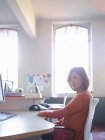 Feminino trabalhador de escritório sentado na mesa — Fotografia de Stock
