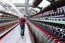Männlicher Fabrikarbeiter überwacht Webmaschinen in Wollspinnerei — Stockfoto