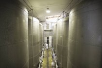 Великі резервуари в пивоварні з далеким працівником — стокове фото