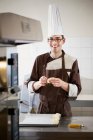 Baker shaping dough in kitchen — Stock Photo