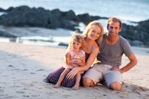 Молодая семья с дочерью на пляже — стоковое фото