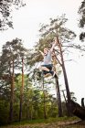 Rapaz saltando na floresta — Fotografia de Stock