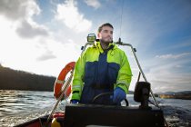 Lavoratore che guida la barca nel lago rurale — Foto stock