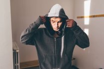 Man in shade wearing hooded top looking down — Stock Photo