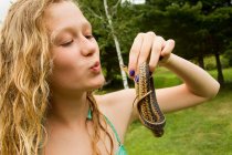 Adolescente chica sosteniendo pequeña serpiente - foto de stock