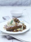 Sausages, mashed potatoes and gravy with sage garnish on white plate — Stock Photo