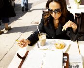 Femme mangeant dans un restaurant extérieur — Photo de stock
