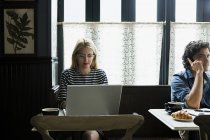 Жінка працює на ноутбуці в кав'ярні — стокове фото