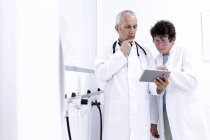 Due medici che guardano tablet digitale — Foto stock