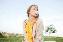 Jeune femme soufflant chewing-gum — Photo de stock