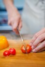 Woman slicing cherry tomatoes — Stock Photo
