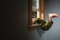 Beine von Junge klettern aus Fenster — Stockfoto