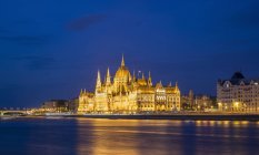 Vista lejana del Parlamento iluminado por la noche, Hungría, Budapest - foto de stock