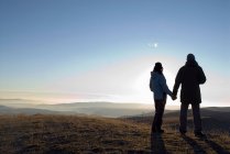 Couple holding hands on mountain hill — Stock Photo