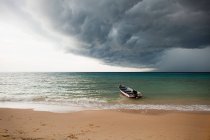 Barco en el mar bajo el cielo tormentoso, Perhentian Kecil, Malasia - foto de stock