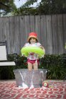 Retrato de menina com anel de borracha em pé no banho de espuma no jardim — Fotografia de Stock