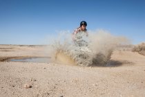 Человек на четырёхколёсной машине в пустыне — стоковое фото