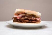 Sándwich de tocino en el plato - foto de stock