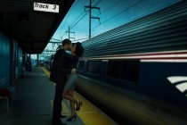 Couple kissing at train station — Stock Photo