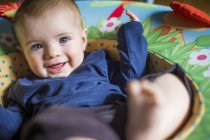 Bébé fille dans le siège bébé regardant la caméra souriant — Photo de stock