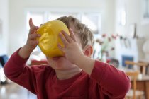 Young boy holding yellow breakfast bowl up to his mouth — Stock Photo