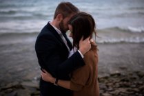 Romantic adult couple hugging on beach at dusk — Stock Photo