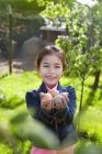 Молодая девушка держит яйца в саду — стоковое фото