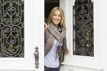 Mitte erwachsene Frau öffnet Haustür — Stockfoto