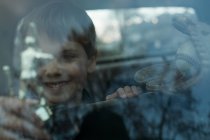 Junge mit Trophäe durch Fenster — Stockfoto