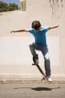 Мальчик-подросток прыгает со скейтбордом — стоковое фото