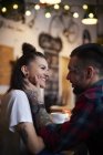 Couple in coffee shop face to face smiling — Stock Photo