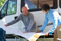 Couple looking at map outside campervan — Stock Photo