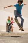 Um adolescente fazendo saltos com um skate — Fotografia de Stock