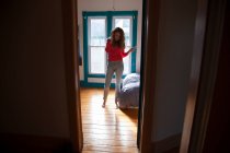 Adolescente em pé no quarto ouvindo MP3 player — Fotografia de Stock