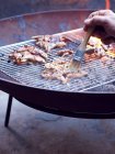 Mans hand painting cooking oil onto coail breast on barbecue — Fotografia de Stock