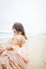 Mother cuddling child wrapped in towel — Stock Photo