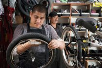 Mecánico trabajando en tienda de bicicletas - foto de stock
