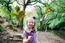 Girl holding an oak branch in a woodland — Stock Photo
