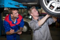 Mecânica do carro discutindo e analisando reparação automóvel — Fotografia de Stock