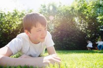 Портрет хлопчика-підлітка, що лежить на траві, дивлячись — стокове фото