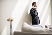 Businessman talking on smartphone in hotel room, Dubai, United Arab Emirates — Stock Photo